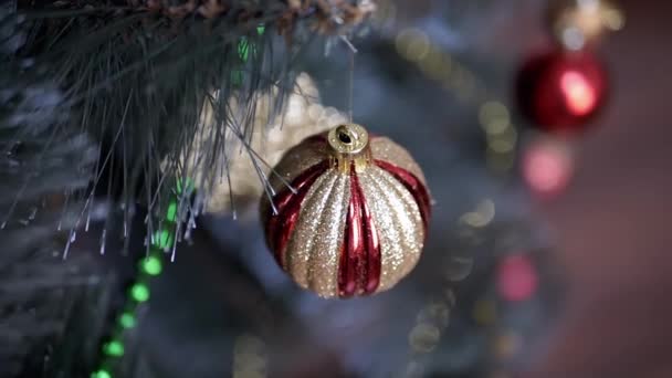 Goldener Glänzender Weihnachtsbaumball Der Auf Einem Verschwommenen Hintergrund Einem Ast — Stockvideo