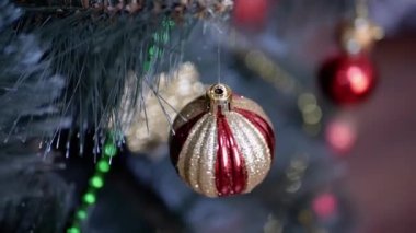 Bulanık bir arka planda, dalda asılı duran Altın Parlak Noel Ağacı Balosu. Kapatın. Döndürme. Noel ağacı süslemesi. Noel süsü. İzole. Olumlu duygular. Mutlu yıllar..