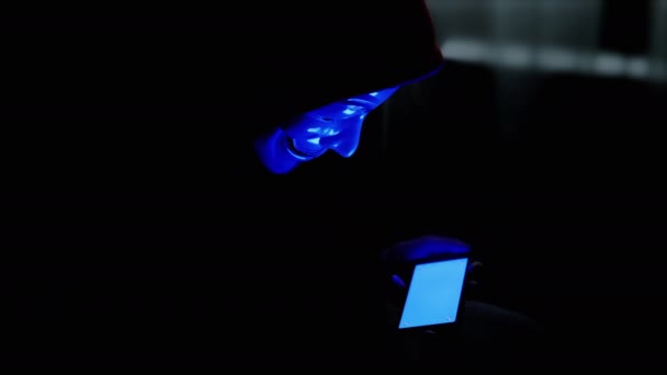 Hacker Mask Sosteniendo Teléfono Inteligente Las Manos Con Una Pantalla — Vídeos de Stock