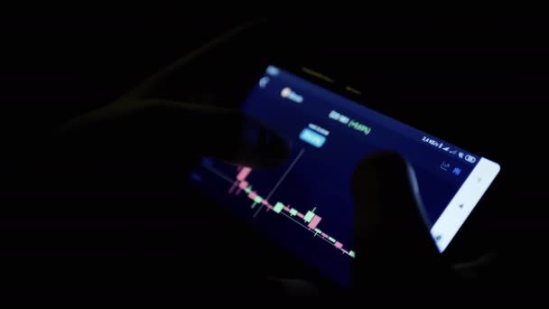 Férfi Megtekintése Cryptocurrency Chart Mobiltelefon App Night Dark Room Kereskedő — Stock videók