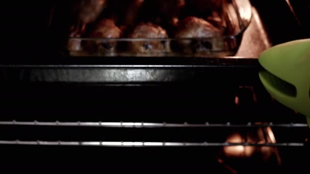 一个女人从烤箱里拿出煮好的多汁炸鸡腿 热烘烘的炸鸡腿 在家里的厨房里夹着脆皮 厨师准备了一顿美味的鸡肉午餐 感恩节 — 图库视频影像