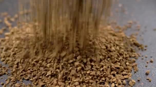 インスタントコーヒー顆粒秋と黒の背景にヒープに散布 スローモーション 閉めろ 茶色の粉 金粒子 可溶性コーヒー顆粒の流れが山に飛び込む — ストック動画