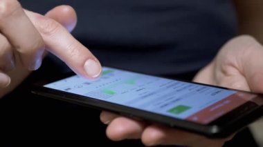 Mobil Telefondaki Dokunmatik ekranda şifreli para birimi grafiği. Business Woman akıllı telefon ekranına parmağıyla dokunuyor. Büyüme çizelgesi, kriptonun düşüşü. Dinamik. Mobil Uygulamada hisse senedi verileri.