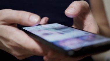 Kadın Parmaklar, Sosyal ağlardaki Haber Kaynağı 'nda bir cep telefonunda geziniyor. Yakın plan. Akıllı telefondan mobil uygulamalara bakan bir kadın. Parmaklar ekrana değsin. Akıllı telefonda hayat..