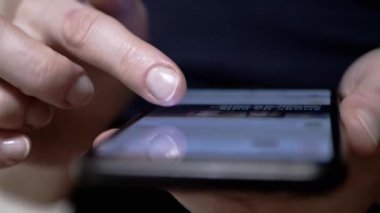 Kadın Parmaklar, Sosyal ağlardaki Haber Kaynağı 'nda bir cep telefonunda geziniyor. Yakın plan. Bir kadın akıllı telefondan mobil uygulamalara göz atıyor. Parmaklar ekrana değsin. Akıllı telefonda hayat..