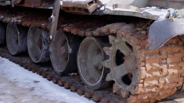 Yanmış, kar, Rus işgalcilerden oluşan harabe bir askeri tankın Rusty Tracks 'ini kaplamış. Yan görüş. Yakın plan. Yanmış askeri teçhizat kalıntıları. Rus işgali Ukrayna 'da. - Savaş. Savaş, savaş. Kyiv.