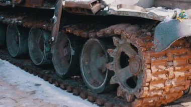 Burnt, Snow Covered Rusty Tracks of a Wrecked Military Tank of Russian Occupiers. Side view. Close-up. Remains of burnt military equipment. Russian invasion of Ukraine. War. Combat, battle. Kyiv.