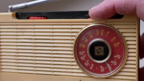 近距离 男性手指在一个老式复古接收机上调整频率 波段设置 调频波频搜索 旋转拨号 旧的黄色手提式无线电接收机 带有手动调音 70年代 — 图库视频影像