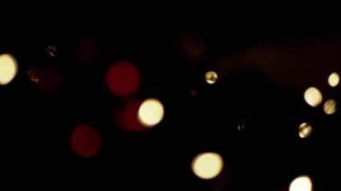 Yanıp sönen Noel Ampulleri, bulanık bir Noel Ağacı Arkaplanındaki Oyuncaklar. Göz kırpan altın ampuller ve çelenklerle odaklanmamış soyut bir arka plan. Bulanık bokeh. Noel süsü. Xmas.