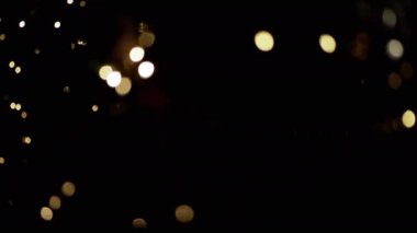 Yanıp sönen Noel Ampulleri, bulanık bir Noel Ağacı Arkaplanındaki Oyuncaklar. Göz kırpan altın ampuller ve çelenklerle odaklanmamış soyut bir arka plan. Bulanık bokeh. Noel süsü. Xmas.