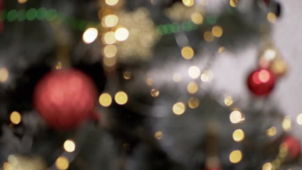 Flackernde Weihnachtsglühbirnen Spielzeug Auf Einem Verschwommenen Christbaumhintergrund Unfokussierter Abstrakter Hintergrund — Stockvideo