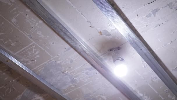 停止およびプラスチック天井のためのアルミニウムプロファイルの天井に金属フレーム トップへのカメラの動き 改修工事の準備 ランプ 照明をオンにします 修理完了だ プラスター スペース — ストック動画
