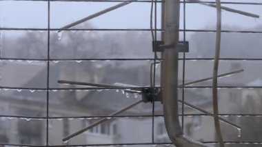 Eski Ev Arkaplanındaki Televizyon Anteninin Izgarası Üzerine Donmuş Yağmur Damlaları. Kapatın. Evlerin, çatıların geçmişi bulanık. Bulutlu sonbahar sisli günü. Yağmurlu soğuk hava. Çiseleyen yağmur. Gri gökyüzü.
