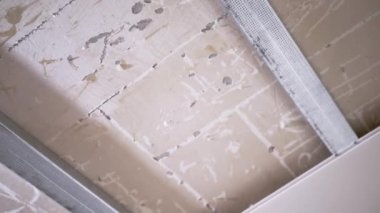 Askıya Alüminyum Profiller ve Plastik Tavan Metal Çerçevesi. Kamera baştan aşağı hareket ediyor. Hazırlık yenileme işi. Tamir et, bitir. Ev, oda. Sıva. Boşluk. Servis.