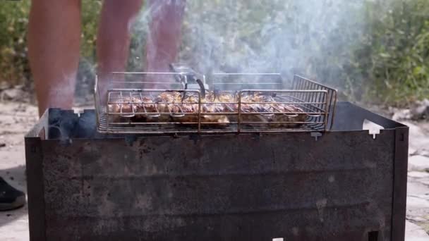 家庭厨师在烤架上煮多汁的肉 在阳光下的后院烧烤 把烤面包放在明火上 放在生锈的炉子上 在炽热的煤烟中 身体的一部分 群体人士 — 图库视频影像