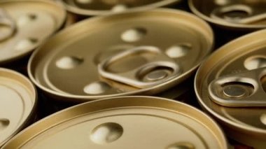 Yaklaşın, Yavaş Metal Kutular Konserve veya Ezmeli. Makro. Üst Manzara. Kapalı altın kutular ve çekiş halkaları. Konserve turist yemeği ya da ıslak evcil hayvan maması, börek. Askerlere askeri ve insani yardım.