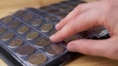 Eski Sovyet Bozukluklarıyla Numismatik Albümün Sayfalarını Yapraktan Eller. Kapatın. Bir koleksiyoncu bir albümde antika para koleksiyonunu inceler. Hobi olarak. Bozuk para topluyorum. Açık arttırma. Boş zaman.