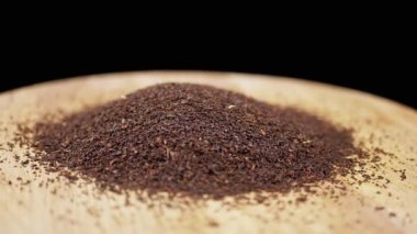 Kara Arkaplanda Tahta Tabakta Dönen Kurutulmuş Siyah Çay Yaprakları. Uzayı kopyala Bol miktarda kuru çay. Yığın. Şifalı bitki. Hareket. İçelim. Soyut. Doku. Parçacık, granül. Dön. Yavaş çekim.
