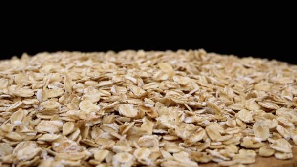 Close Dry Oat Flakes Slowly Rotate Wooden Plate Black Background — Stock Video