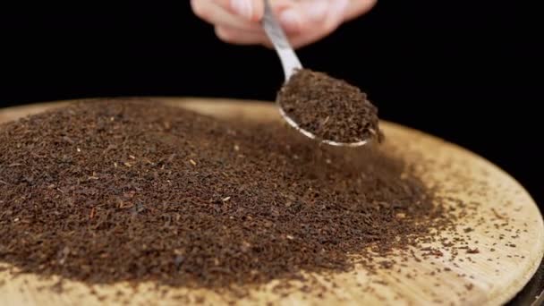 Hand Sprinkles Dried Black Tea Leaves Spoon Rotating Surface Dalam — Stok Video