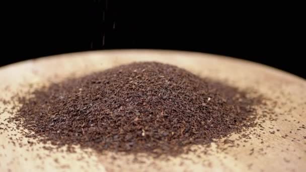 Spadające Granulki Suszonych Liści Czarnej Herbaty Obracającej Się Drewnianej Płycie — Wideo stockowe