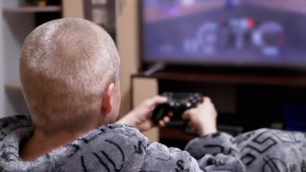 Азартні Ігри Чоловік Теплому Сірому Халаті Граючи Відеоігри Сидячи Кімнаті — стокове відео