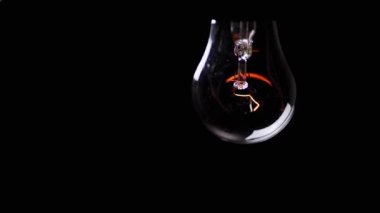 Kara Arkaplan 'daki Karanlık Oda' da sallanan titreşimli ampul. Yaşlı Edison tungsten parlıyor ve kapanıyor. Enerji krizi. Elektrik var. Elektrik kesintisi. Kesinti. Değiştir.