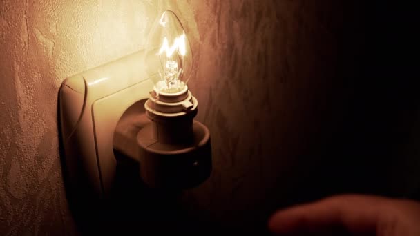 Mão Desliga Uma Lâmpada Brilhante Luz Noturna Inserida Soquete Parede — Vídeo de Stock