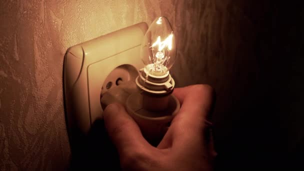 Person Hand Inserts Flickering Light Bulb Night Light Socket Wall — Stock Video