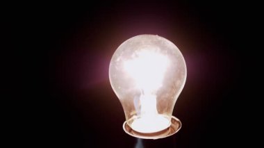 Yaklaş, Eski Parıldayan Edison Siyah Arkaplanda Yanan Ampul. Parlak tungsten lamba açılıp kapanıyor. Flaş. Merhaba. Sıcak sarı ışık. Yapı. Elektrik, enerji krizi. Kesinti.