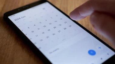 Kadın Parmak, Tarih Arayan Cep Telefonu Ekranında Takvim Uygulaması Kaydırıyor. Kapatın. 2024 yıl, ay, gün, tarih. Sevgililer Günü 'nü ara. Akıllı telefondan elektronik takvim. İzole edilmiş.