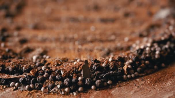 Mischung Aus Schwarzen Pfefferkörnern Auf Einem Rotierenden Holzhintergrund Aus Getrockneten — Stockvideo