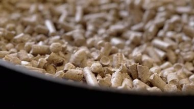 Ezilmiş Tahta talaşının granülleri Dönen Arkaplanda Pelletler Yığını 'na düşüyor. Kapatın. Biyoyakıt, doğal organik kedi kumu. Dolduruyorum. Cipsler, briketler. Yenilenebilir enerji. Doku. Ağır çekim. Döngü.