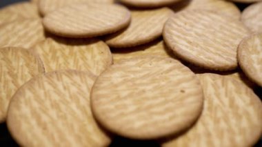 Yaklaş, Yuvarlak Kıtır Kurabiye Turntable 'da Dönüyor, Arka plan. Lezzetli krakerler. Üst Manzara. Sağlıklı gıda konsepti. Tatlı hamur işleri. Yemek arkaplanı. Satılık. Doku. Yavaş çekim.