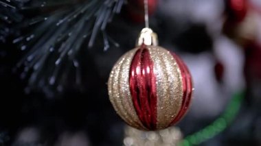 Bulanık bir arka planda, dalda asılı duran Altın Parlak Noel Ağacı Balosu. Kapatın. Döndürme. Noel ağacı süslemesi. Noel süsü. İzole. Olumlu duygular. Mutlu yıllar..