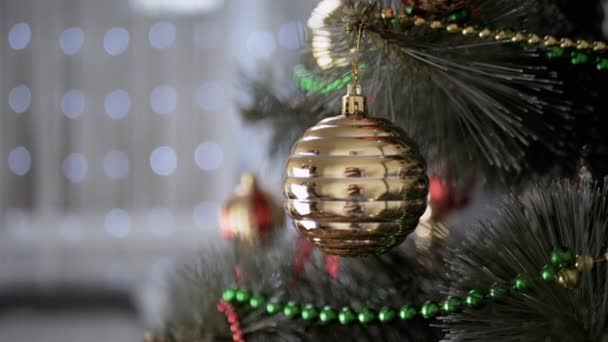 Golden Glänzende Weihnachtskugel Die Einem Fichtenzweig Auf Einem Hintergrund Aus — Stockvideo