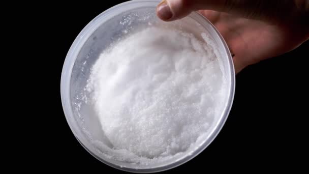 Mano Humana Sosteniendo Contenedor Plástico Con Nieve Azúcar Sobre Fondo — Vídeos de Stock