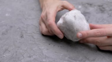 Yaklaş, Kadın Kirli Kartopu Tutuyor Gri Beton Arkaplanda. Doku, soyut, nesne. İzole edilmiş arka plan. Vücudun bir parçası. Tanımlanamayan kişi. Buz topu. Kış konsepti.