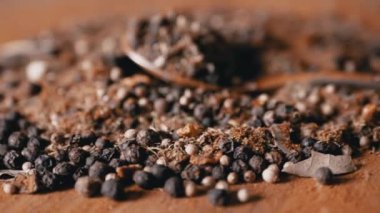 Yaklaş, Kırmızı Tahta Arkaplanda Hint Baharatları Dönüşümlü Spoon. Yığın. Baharat karışımı, siyah ve kırmızı biber taneleri, kırmızı biber, kişniş. Geçmişi ve dokusu. Döngü. Kurutulmuş baharatlar..