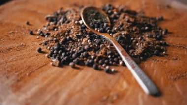 Renkli ahşap bir arka planda Hint Baharatları Rotasyonu ile kaşık. Kapatın. Ağır çekim. Yığın. Baharat karışımı, karabiber, zerdeçal, paprika, kişniş, kekik. Arkaplan ve doku.
