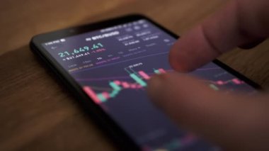 Tüccar, Online Smartphone 'da Bitcoin Fiyat Değişiklikleri Grafiği izliyor. Borsa, kripto para ticareti. Parmak ekrana dokunur. Mali göstergeler, kripto büyümesi, düşüş verileri. Forex çizelgesi.