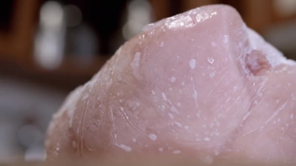在旋转的背景上用冰块覆盖了一大块冻肉 靠近点结冰的鸡肉片和结冰的雪皮 食物解冻了 孤立无援选择性焦点 — 图库视频影像