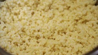 Yakın plan, Sarı Millet Lapası Dönen Arkaplanda bir tencerede. Kavanozda kaynamış darı lapası. Doku, yavaş dönüş. Makro. Akşam yemeği ve kahvaltı için sağlıklı yiyecekler. Ev mutfağı.