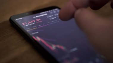 Tüccar, Online Smartphone 'da Bitcoin Fiyat Değişiklikleri Grafiği izliyor. Borsa, kripto para ticareti. Parmak ekrana dokunur. Mali göstergeler, kripto büyümesi, düşüş verileri. Forex çizelgesi.