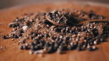 Yaklaş, Hint Baharatları Dönüşümlü Kaşık. Renkli, tahta bir arka planda. Yığın. Baharat karışımı, karabiber, zerdeçal, paprika, kişniş. Geçmişi ve dokusu. Döngü. Yavaş çekim.