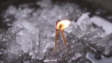 İki Yanan Kibrit Islak Kar Üzerindeki Ateş Ateşine Bağlıdır. Yanmış yanan yanan başların kibritleri parlak bir ateşte öpüşüyor. Eriyen karın arka planına karşı dramatik bir aşk hikayesi. Savaş.