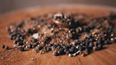 Yaklaş, Kırmızı Tahta Arkaplanda Hint Baharatları Dönüşümlü Spoon. Yığın. Baharat karışımı, siyah ve kırmızı biber taneleri, kırmızı biber, kişniş. Geçmişi ve dokusu. Döngü. Kurutulmuş baharatlar..