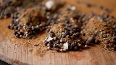 Değişen ahşap arka planda çeşitli çok renkli Hint baharatları serpiştirilmiş. Parlak aromatik kuru baharatların bileşimi. Baharatlı biberler, kurutulmuş bitkiler, dereotu, paprika, zerdeçal, kekik.