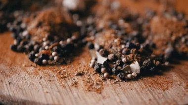 Değişen ahşap arka planda çeşitli çok renkli Hint baharatları serpiştirilmiş. Parlak aromatik kuru baharatların bileşimi. Baharatlı biberler, kurutulmuş bitkiler, dereotu, paprika, zerdeçal, kekik.