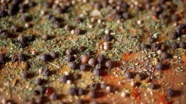 Değişen ahşap arka planda çeşitli çok renkli Hint baharatları serpiştirilmiş. Baharat, karabiber, kurutulmuş otlar, dereotu, paprika, zerdeçal, kekik. Yemek pişirmek için güzel kokulu baharatlar..